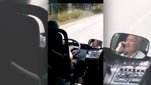 Шофьор на автобус кара с телефон в ръка
