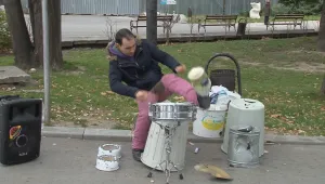 Уличен музикант свири на кош за пране, тенджера и джезве