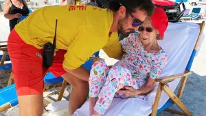 Спасители носят на ръце 95-годишна жена всеки ден до плажа, за да се наслади на океана