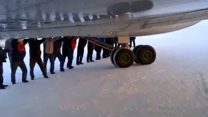 Пътници бутат замръзнал самолет, за да го раздвижат (ВИДЕО)