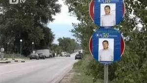Кандидат-кмет се усмихва от пътен знак