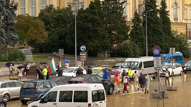 Снимка: Протестиращи пресичат пешеходната пътека пред БНБ в София, има задържан